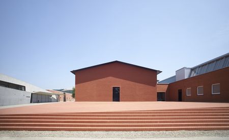 The Vitra campus. Wide steps made from orange bricks lead to the main building, which is made of the same material.