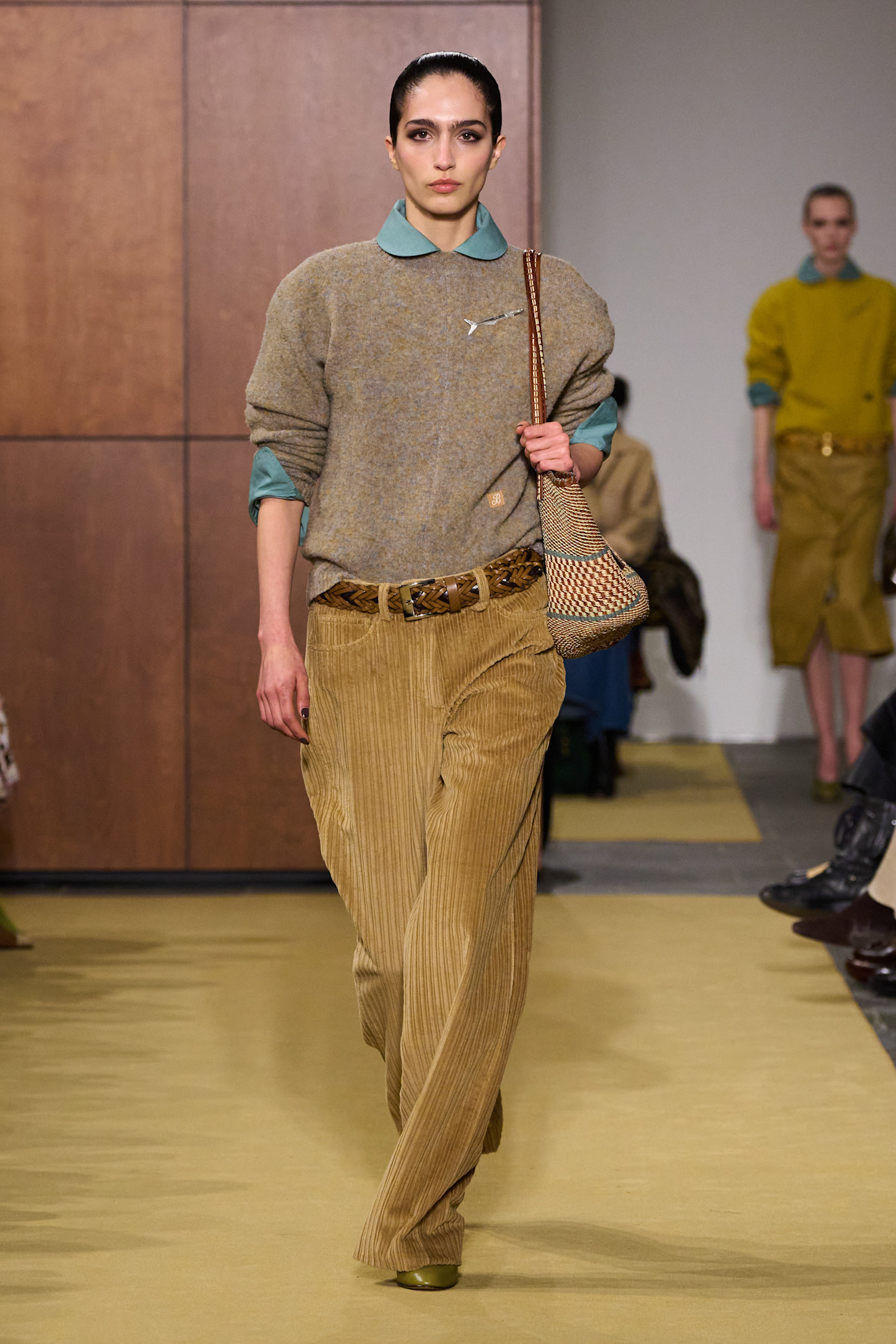 A fall/winter 2026 runway model wearing corduroy trousers.