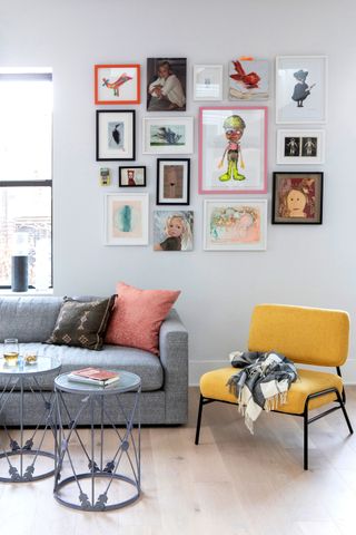 a gallery wall of kids art in a living room
