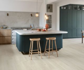 blue kitchen with pale wood-effect vinyl flooring