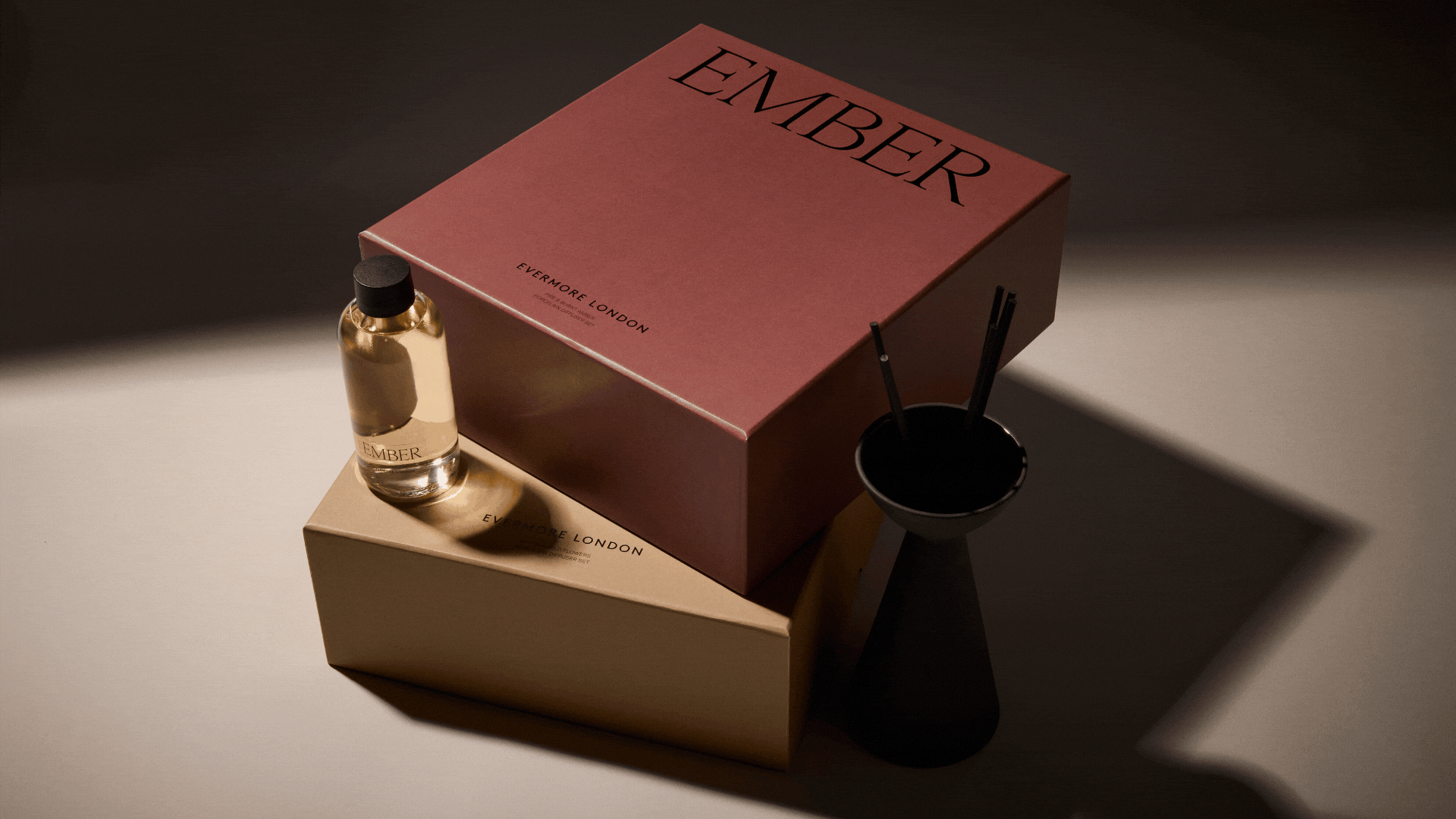 A GIF of a set of black reed diffusers in colored boxes