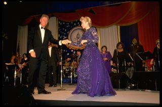 Pres. Bill & Hillary Rodham Clinton joining hands, about to begin dancing, onstage at Kennedy Ctr. inaugural ball