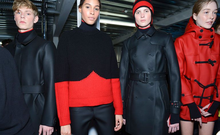 Two women with black leather trench coats, one with a red duffel coat and one with a black and red jumper