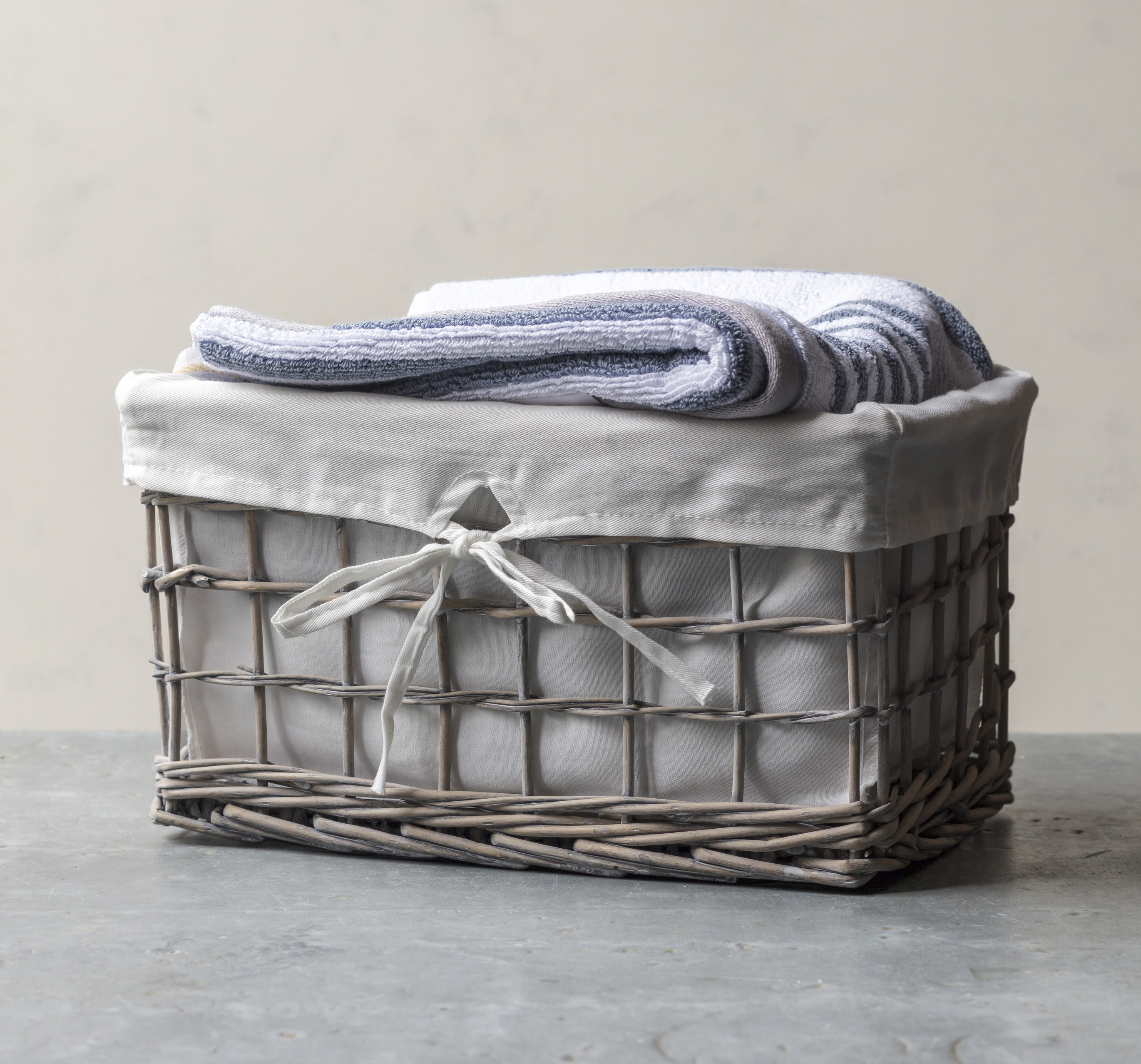 Wicker lined basket in grey for storing towels