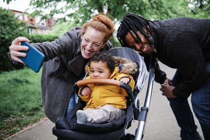 Best pushchairs 2023: cheerful parents taking selfie with son in stroller at park