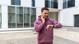 A man checking his pulse while looking at his fitness tracker