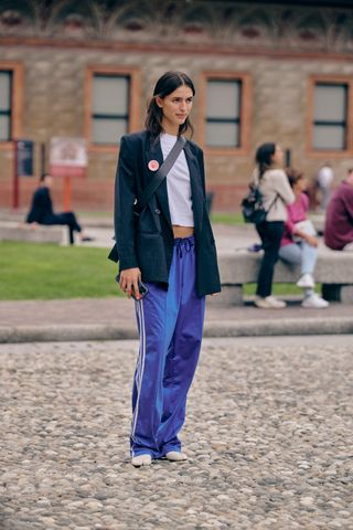 Fashion week spring/summer 2024 attendee wearing blue track pants and black blazer