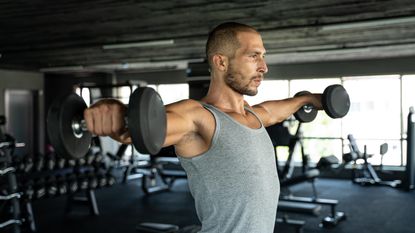 man holding two dumbbells