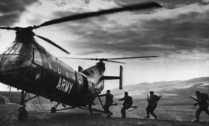 American troops run for a helicopter after a successful attack behind enemy lines during a training session in 1962.