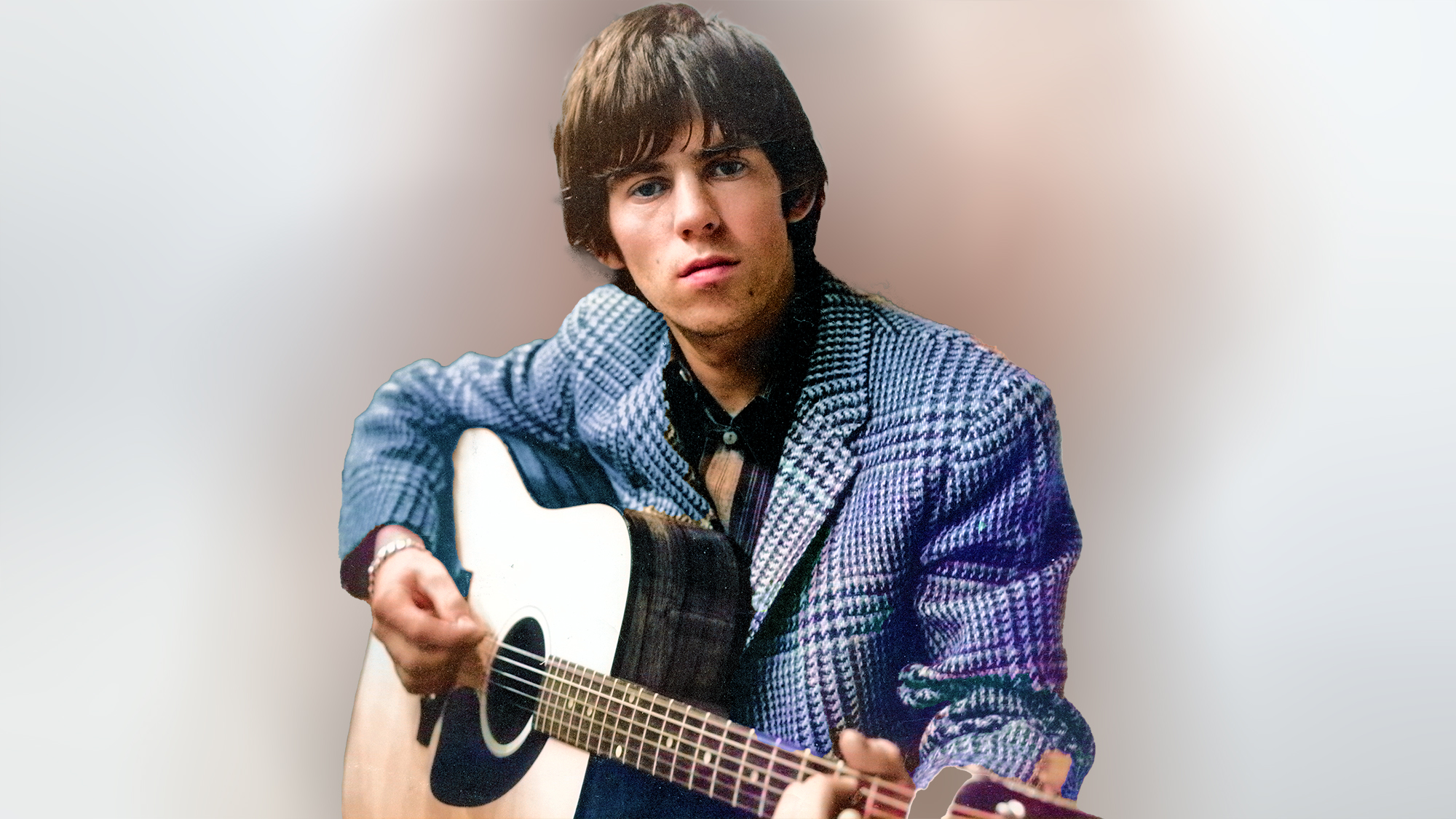 1964: Guitarist Keith Richards of the rock band "the Rolling Stones" poses for a portrait with an acoustic guitar and two men in the background in 1964. 