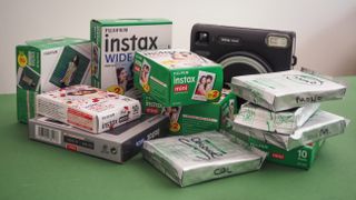 A stack of piled up Instax film on a green surface