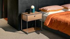 beige steel-frame nightstand next to bed