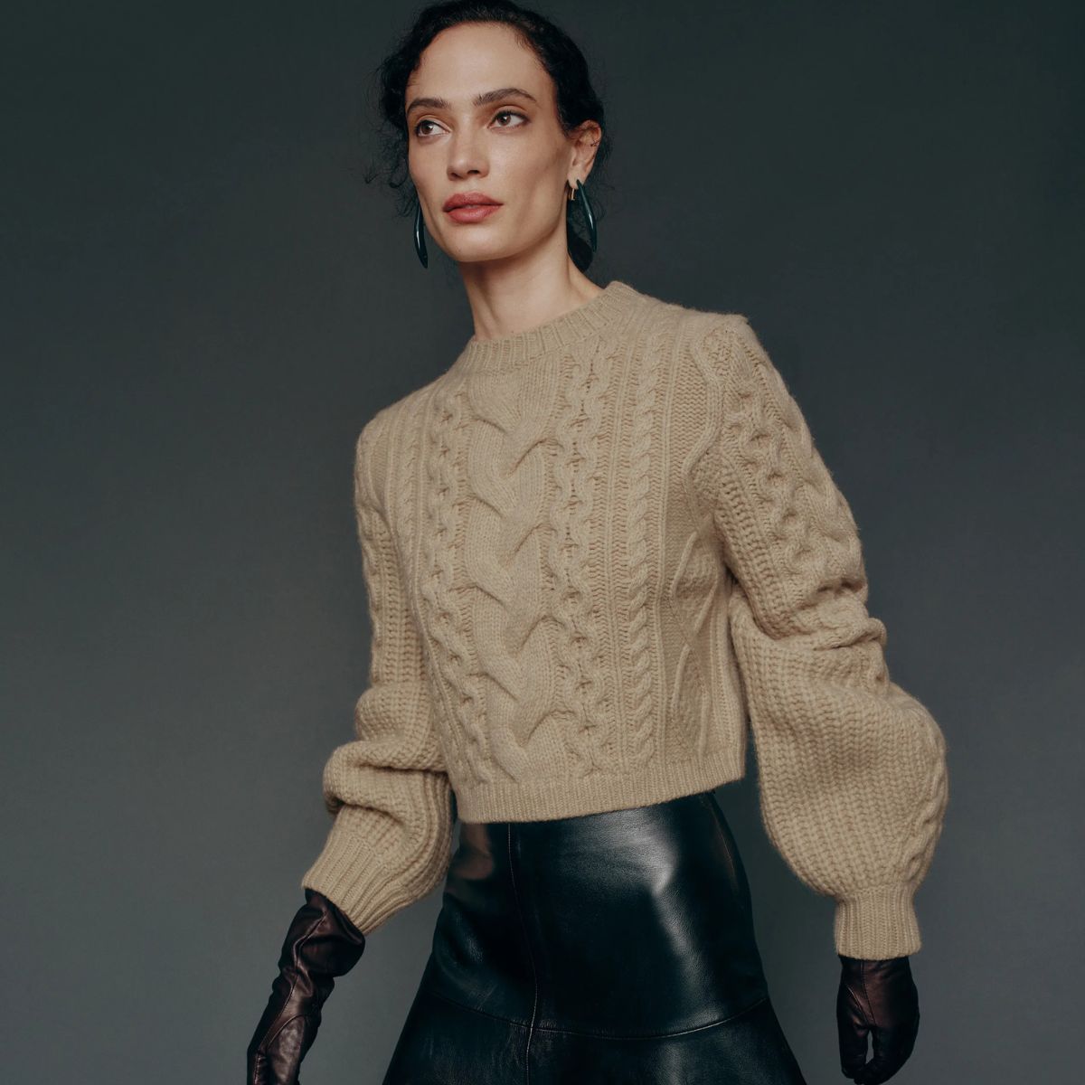 Model wears cable-knit jumper, leather gloves and leather skirt