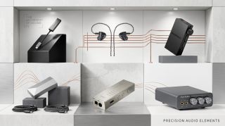 A selection of portable hi-fi products on grey plinths, with a brass rail between them