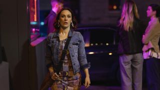 Roisin Gallagher in a patterned dress and denim jacket as Shiv in The Dry season 2