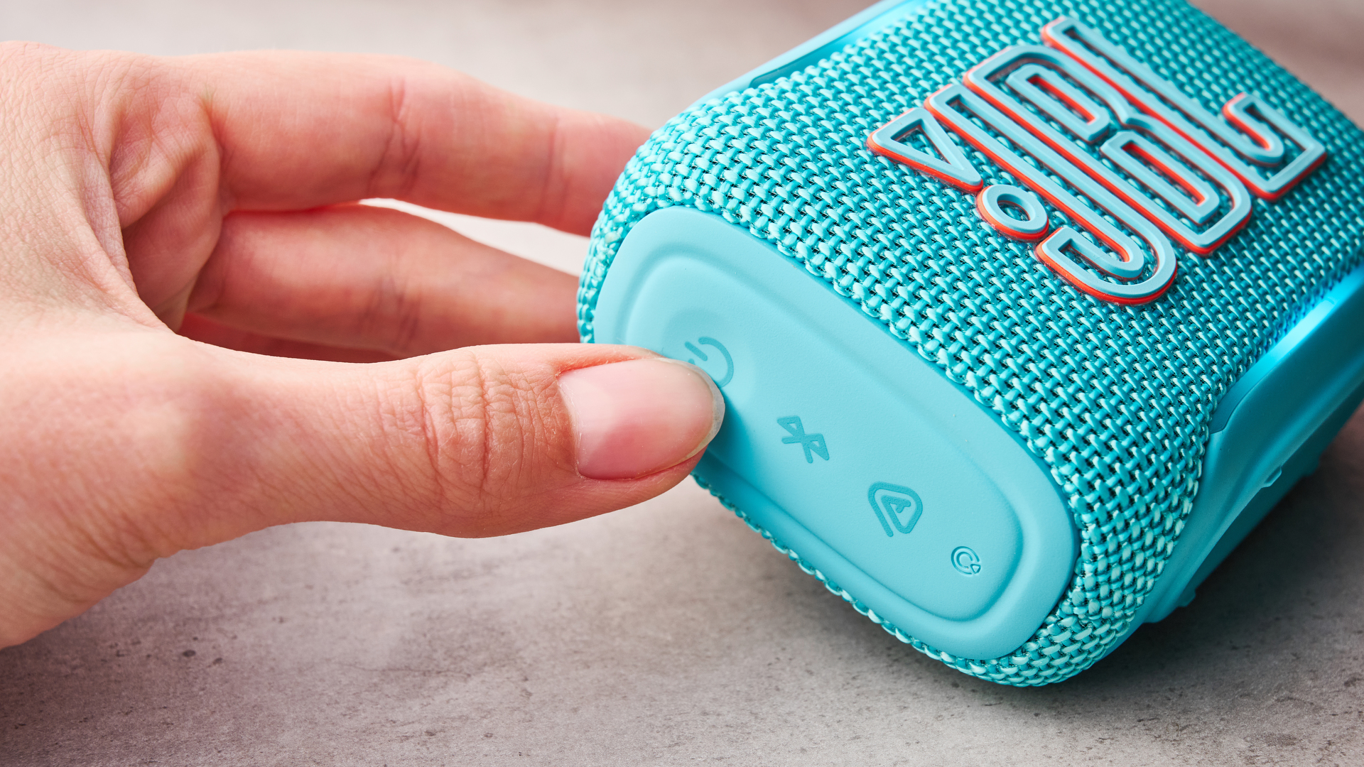 Person turning the JBL Go 5 on