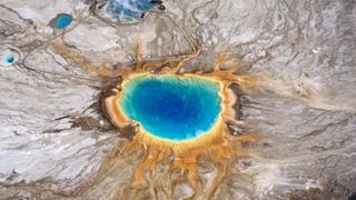 Aerial view of the Grand Prismatic Spring at Yellowstone National Park, with blue center and orange and yellow at the edges