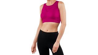 A woman wears a pink sports bra, one of the best high-impact sports bras.