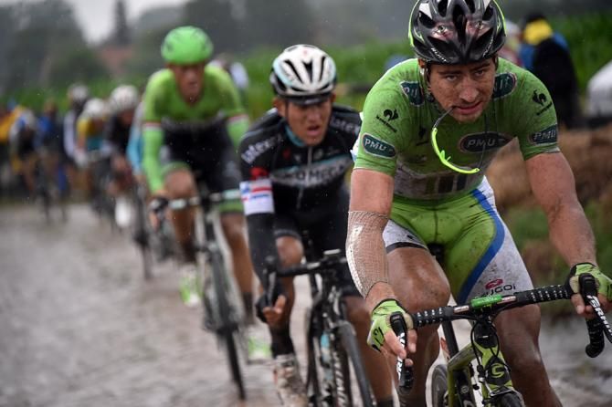 Peter Sagan (Cannondale) holds his mud-spattered glasses in his teeth