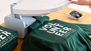Cricut Autopress; a green t-shirt on a heat press machine