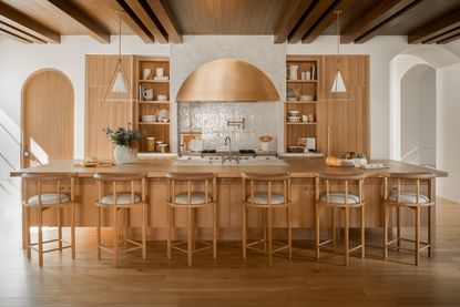 A kitchen featuring fluted wood, plaster and a neutral color palette