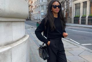 Woman wearing a black sweater with black trousers.