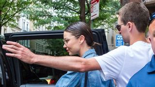 Miranda Kerr being escorted into vehicle by bodyguard