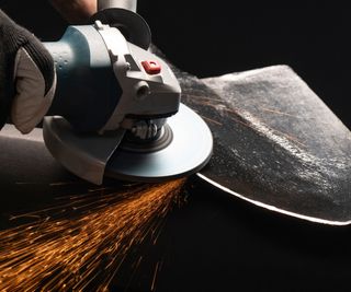 Sharpening a spade with a grinder