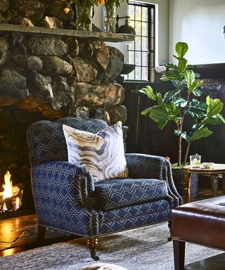 blue patterned armchair by lit fire