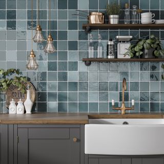 Marlow Turquoise Mix ceramic tiles by Tile Giant in a modern kitchen, with a white butler's sink, a dark wood floating shelf and hanging lights, and dark grey cabinets