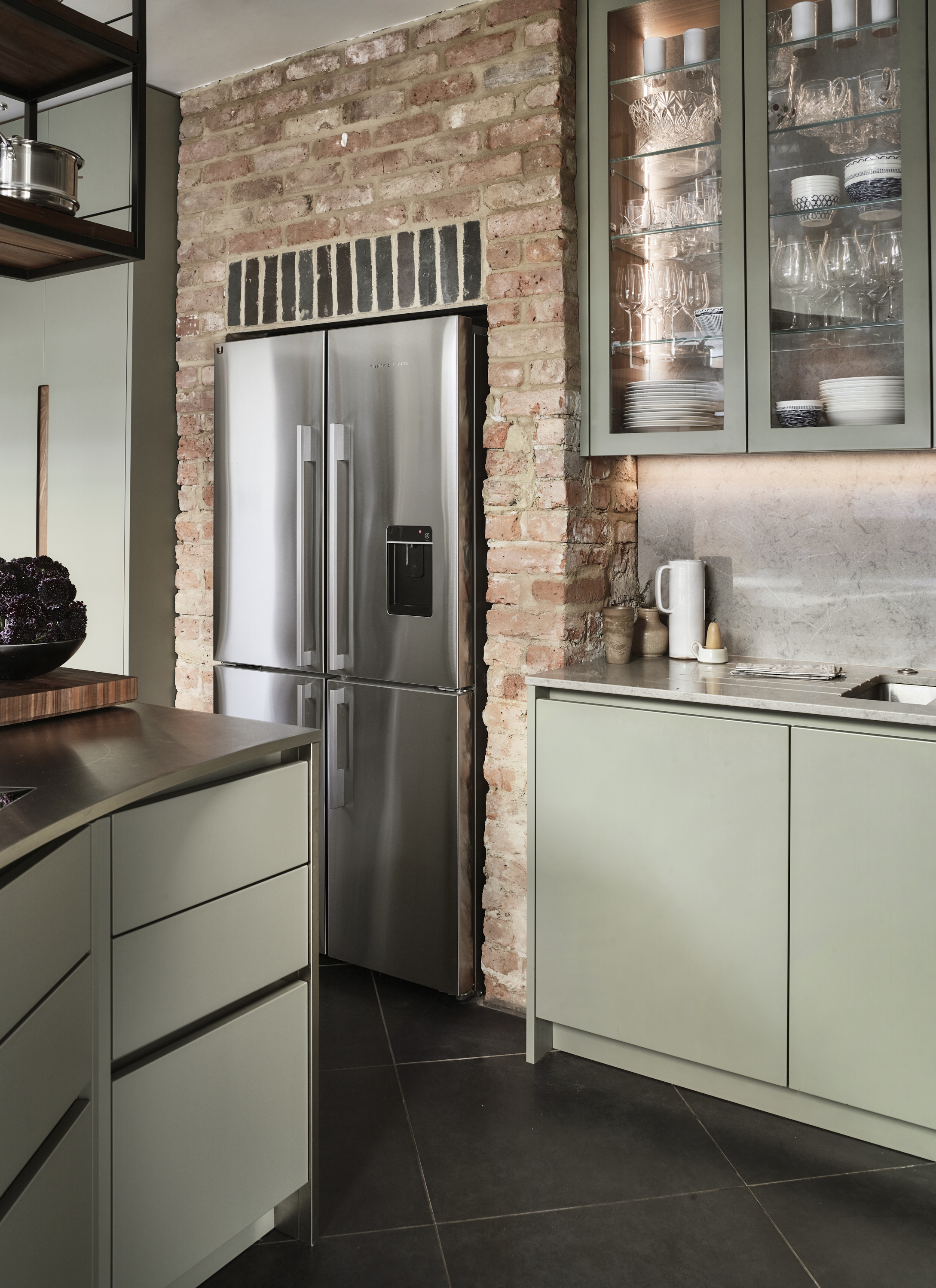 A green-toned kitchen with an angled island