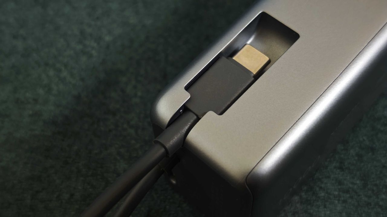 A matte grey Xiaomi 165W Power Bank on a green sofa