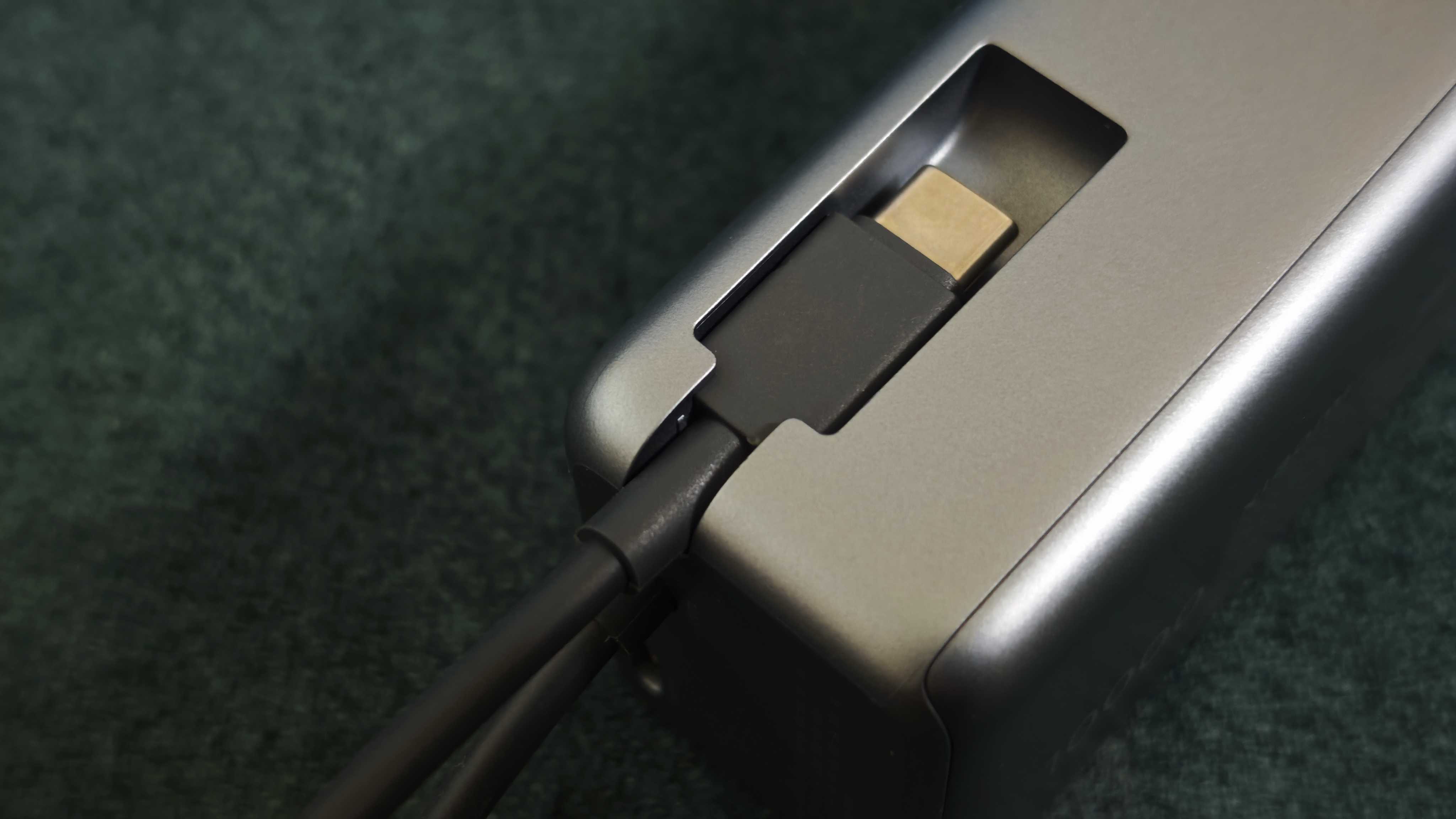 A matte grey Xiaomi 165W Power Bank on a green sofa