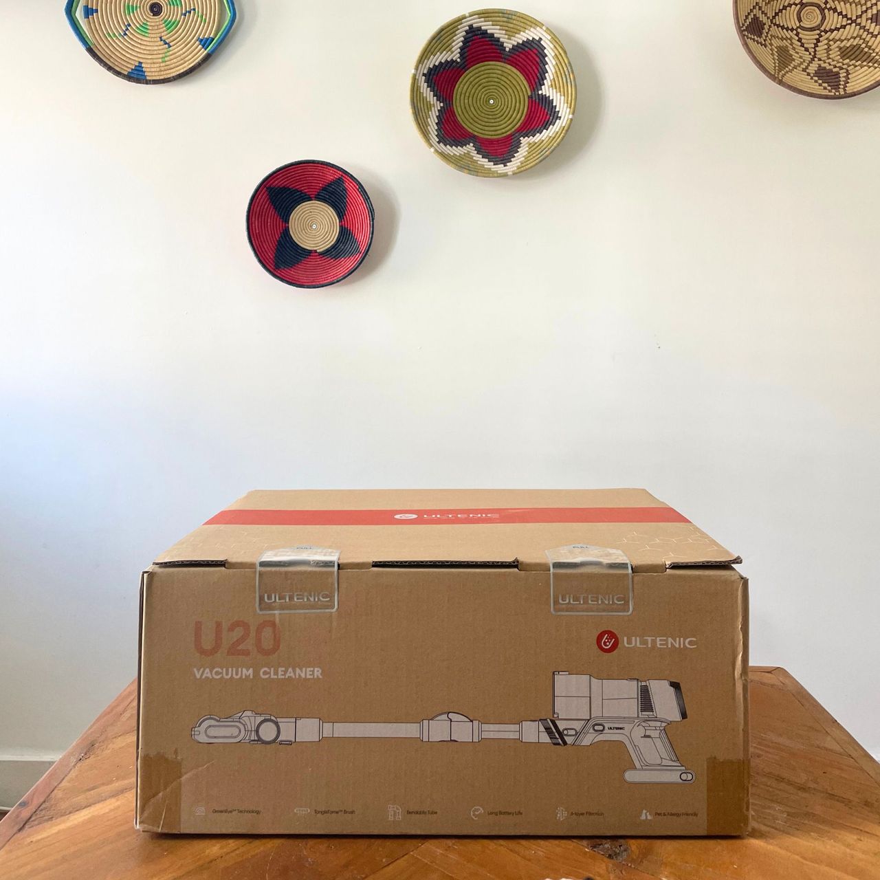 Ultenic U20 cordless vacuum box sitting on a wooden table in front of a white wall