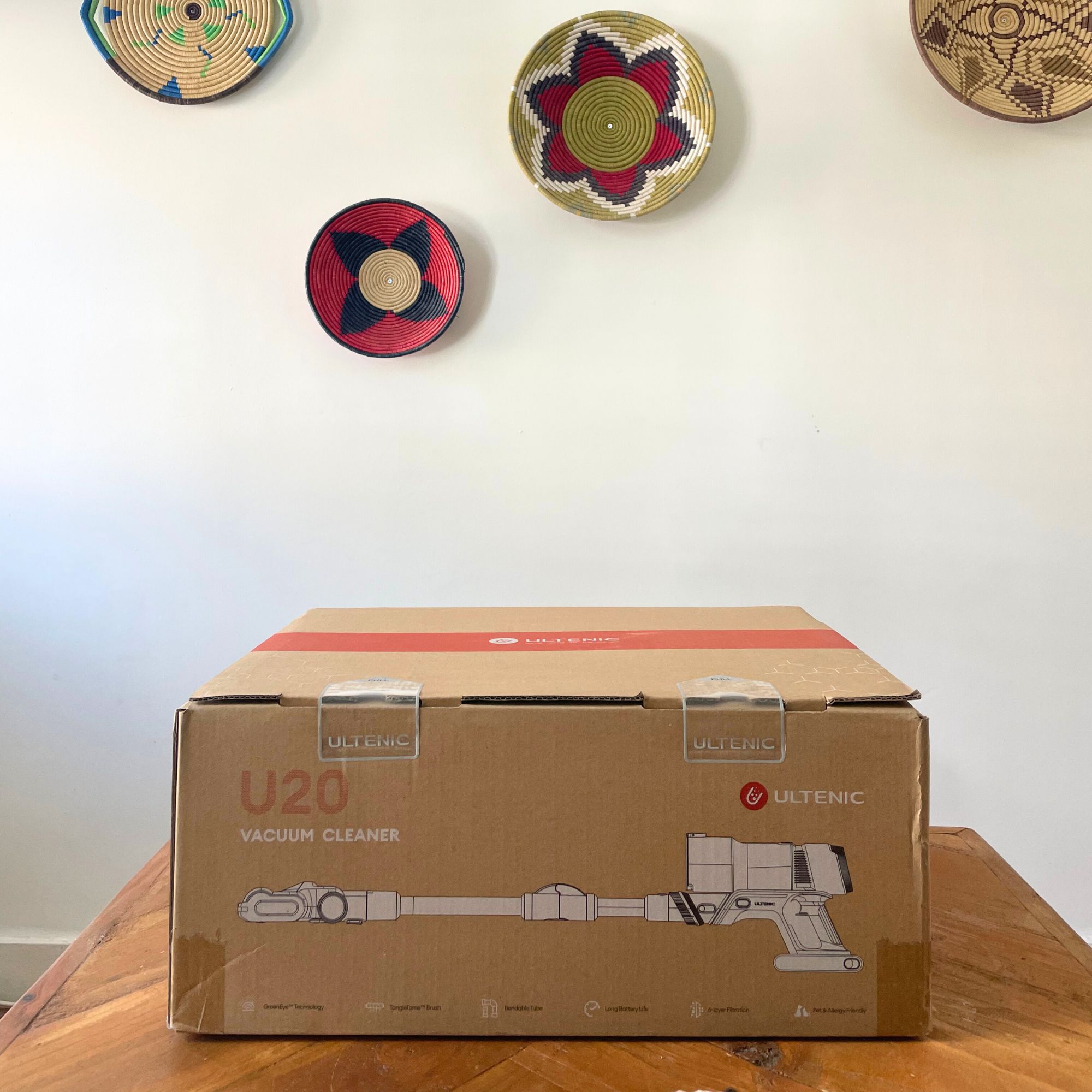 Ultenic U20 cordless vacuum box sitting on a wooden table in front of a white wall