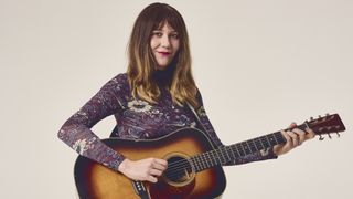 Molly Tuttle photographed with an acoustic guitar in 2024