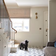 Entrance hall and staircase with monochrome flooring and cream panelled walls