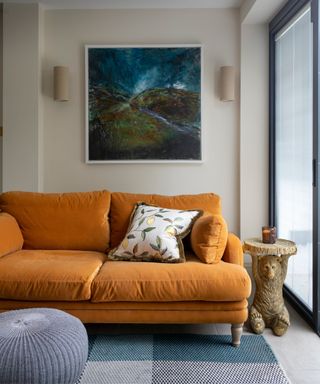 Orange sofa, grey footstool, wooden table