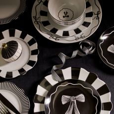 Matalan's black and white bow and stripe- adorned tableware laid out on a dining table