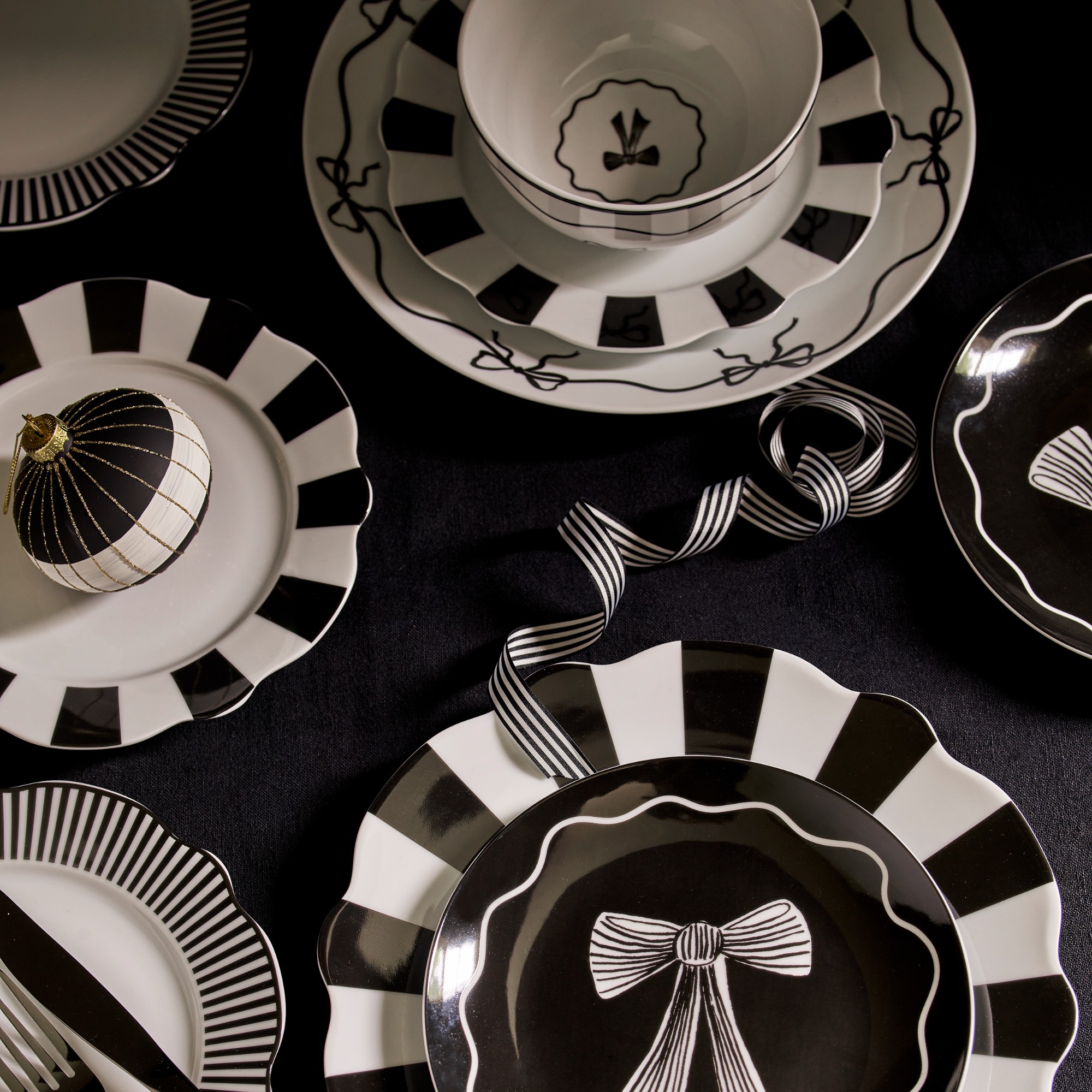 Matalan&#039;s black and white bow and stripe- adorned tableware laid out on a dining table