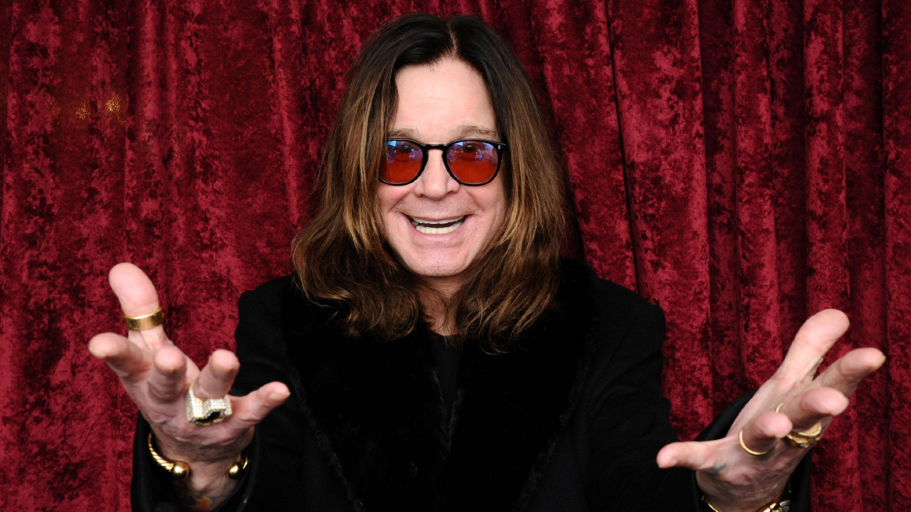 Ozzy Osbourne standing in front of a red curtain