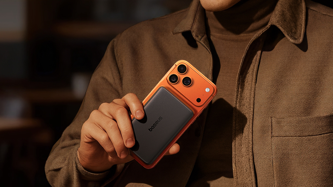 A man holds a smartphone with the Baseus PicoGo attached.