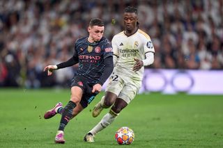 Real Madrid vs Manchester City: Phil Foden of Manchester City is challenged by Eduardo Camavinga of Real Madrid during the UEFA Champions League quarter-final first leg match between Real Madrid CF and Manchester City at Estadio Santiago Bernabeu on April 09, 2024 in Madrid, Spain.