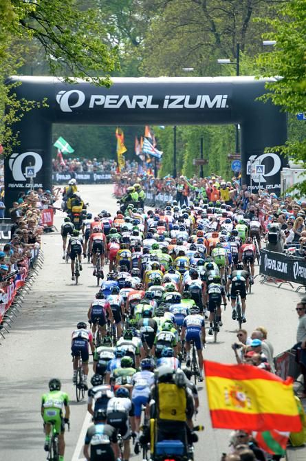 The peloton heads under the banner ahead of the Cauberg