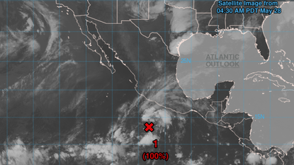 A satellite image shows clouds and storms brewing off the Pacific coast of Mexico. A red "X" marks the location of a system that could develop into a tropical storm.