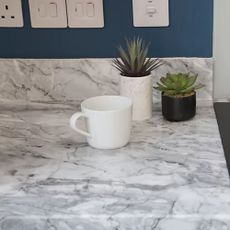 Marble worktop wrap with small plants and mug on top