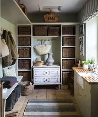 A utility room with floor-to-ceiling shelving featuring woven baskets in cubby holes