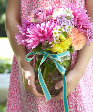 Garden party ideas with young girl holding jar of flowers