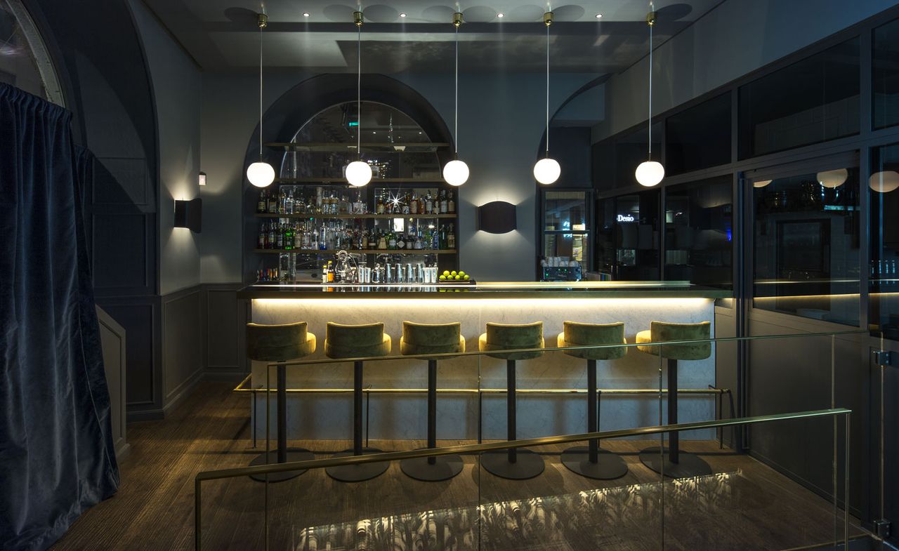 Dark bar with green velvet bar stools