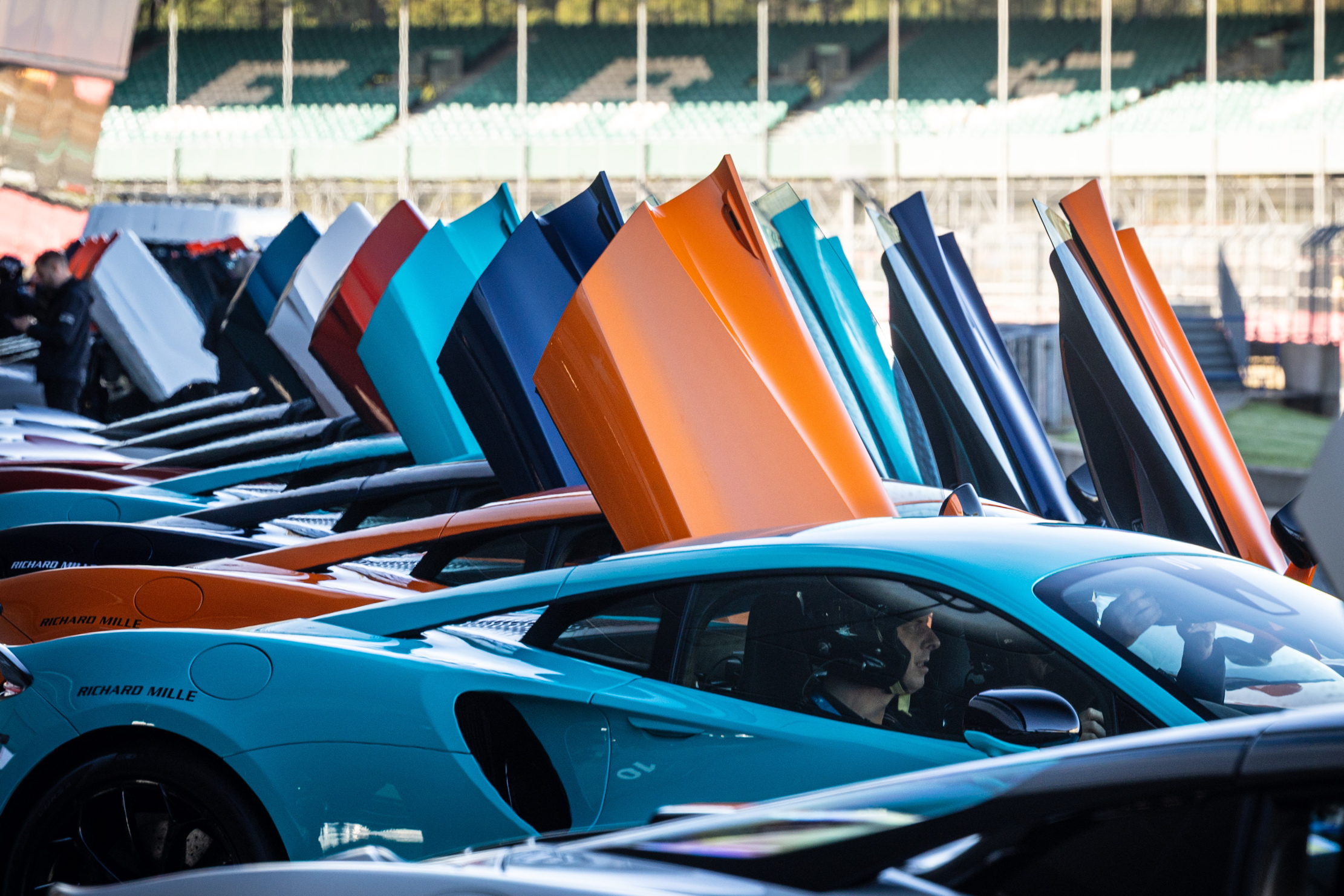 McLarens of many colours with their doors open